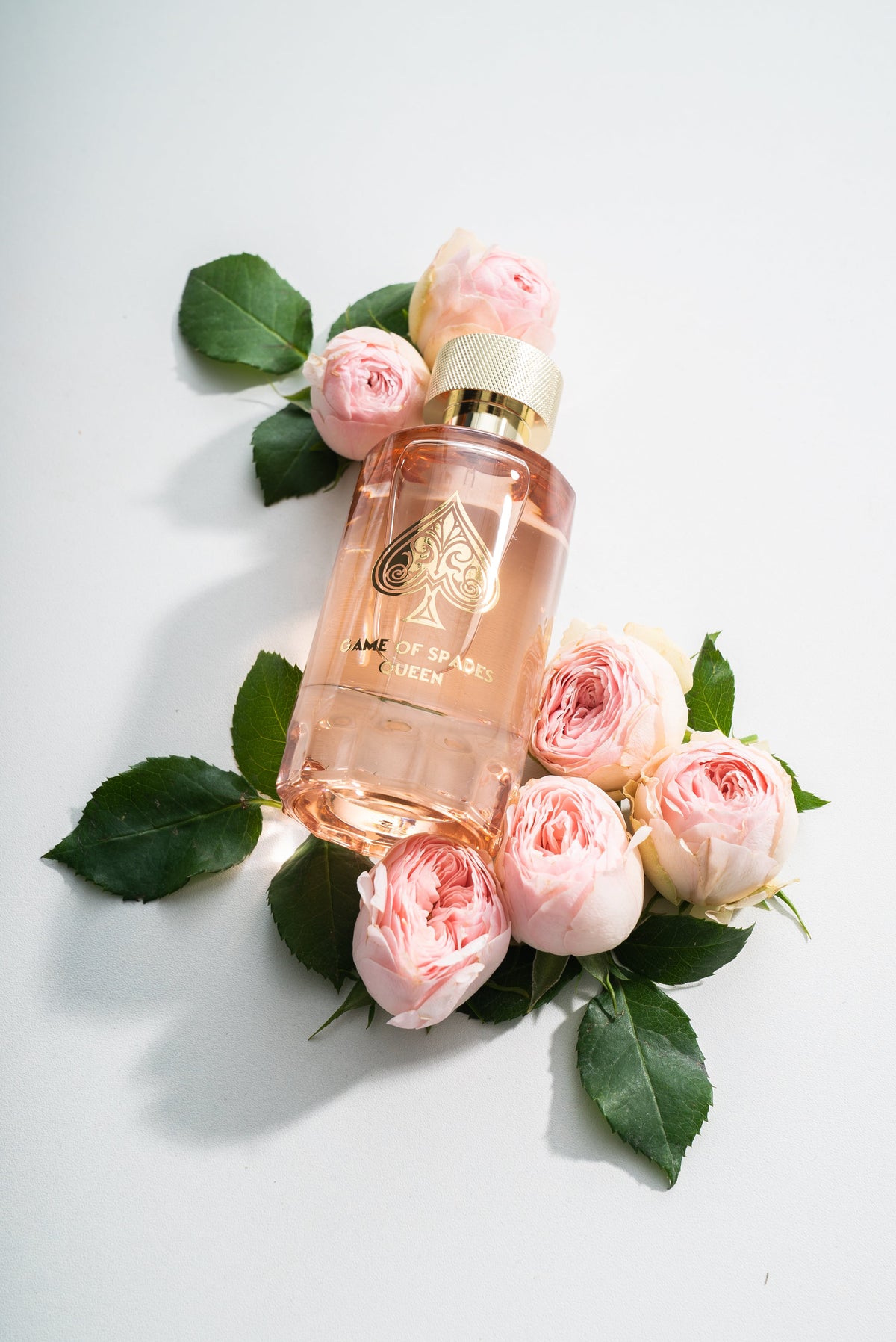 A perfume bottle among pink garden roses