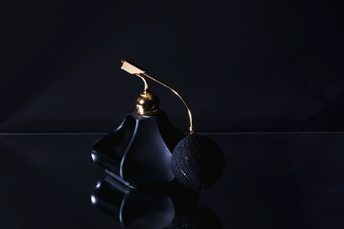 A dark glass perfume bottle in low light