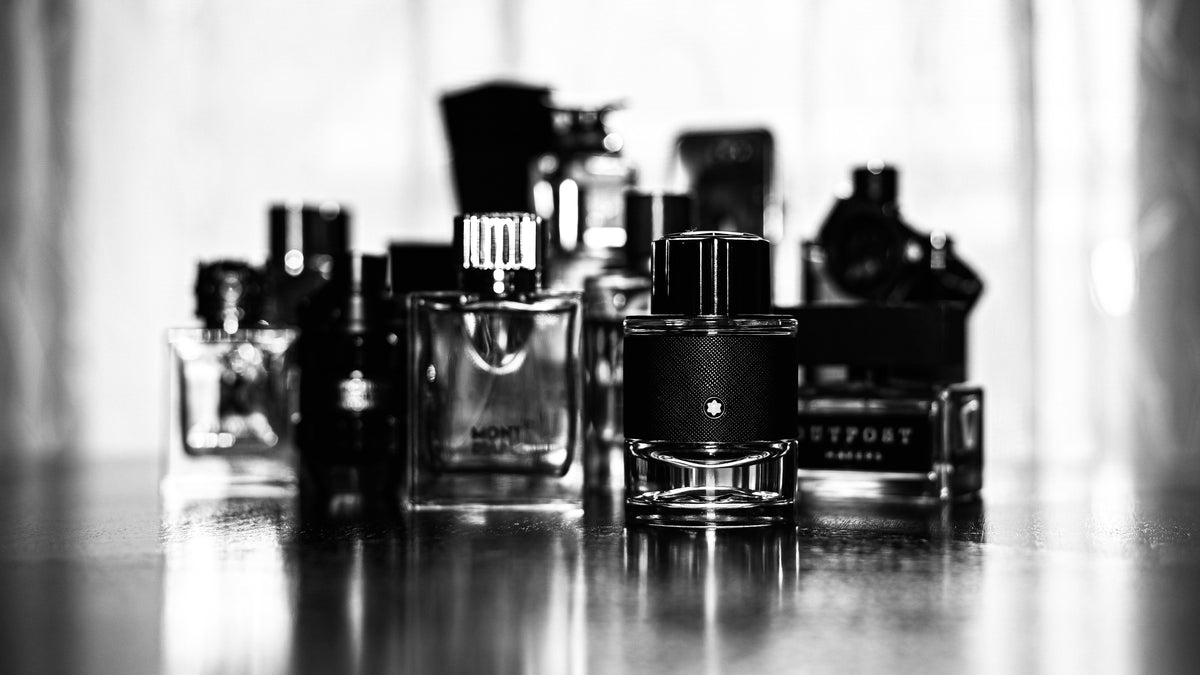 A row of men's perfume bottles in black and white