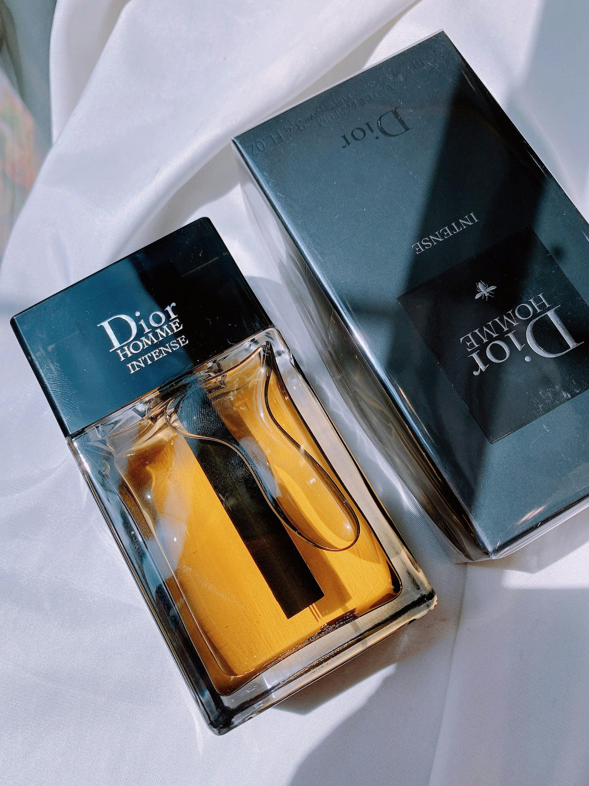 Two bottles of men's eau de parfum in low light